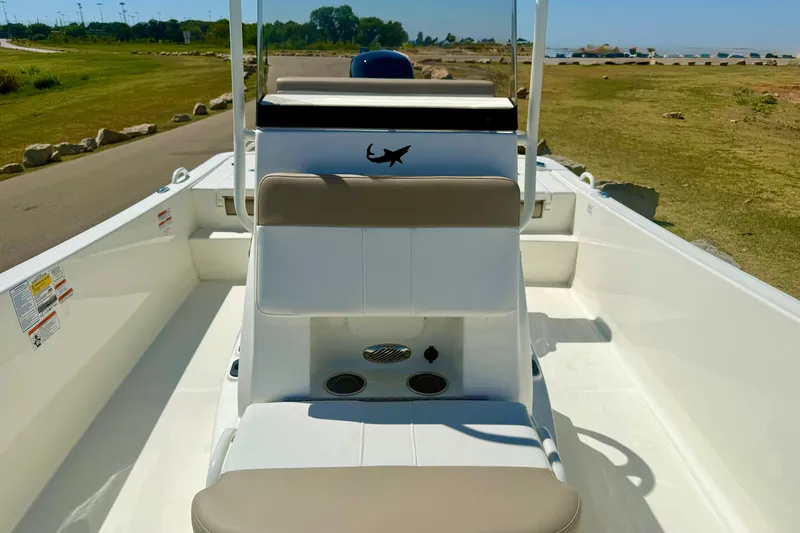 Slide: The Image of 2026 Mako Pro Skiff 19 CC boat interior with seating and console, set in a scenic outdoor location. - 14