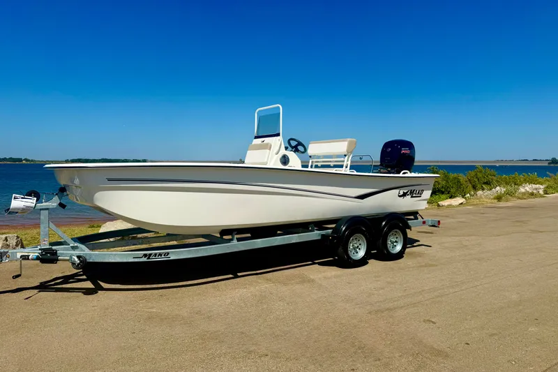 Slide: The Image of 2026 Mako Pro Skiff 19 CC boat on trailer by a scenic waterfront. - 15