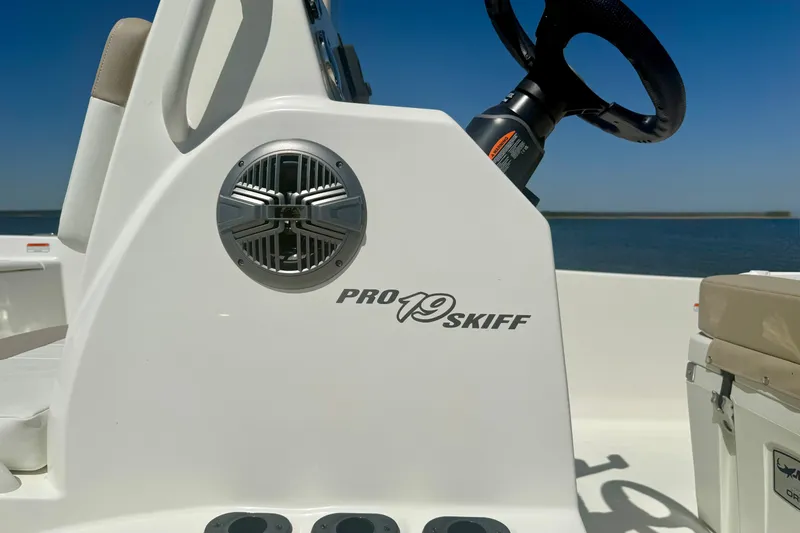Slide: The Image of 2026 Mako Pro Skiff 19 CC boat console with steering wheel and speaker. - 20