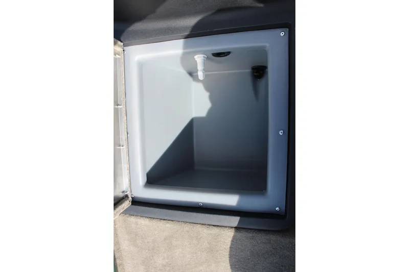Slide: The Image of 2026 Tracker Bass Tracker Classic Limited storage compartment, open and empty, with a drain plug. - 52