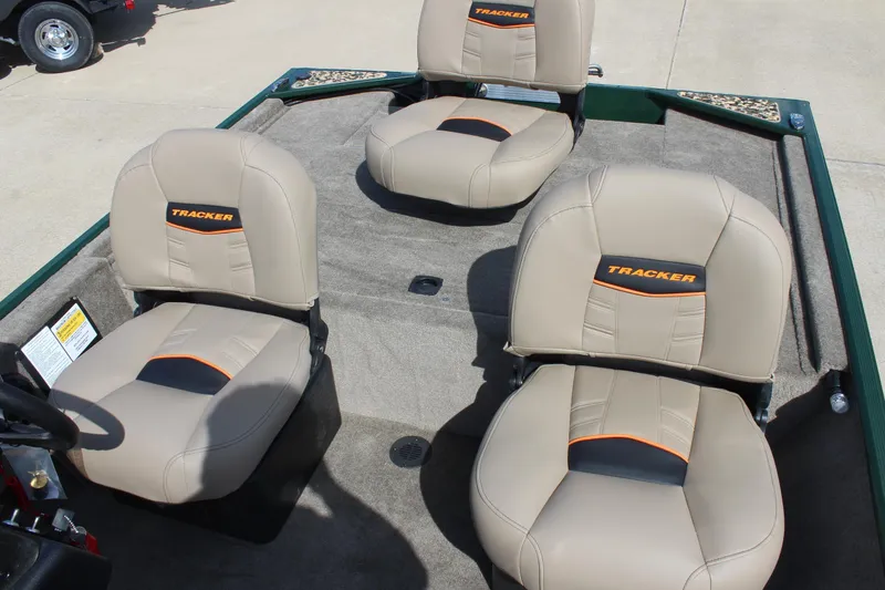 Slide: The Image of 2026 Tracker Bass Tracker Classic Limited boat seats, beige with orange accents, on a carpeted deck. - 53