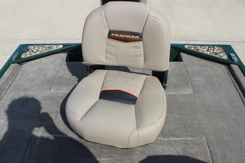 Slide: The Image of 2026 Tracker Bass Tracker Classic Limited boat seat, beige with orange accents, on carpeted deck. - 54