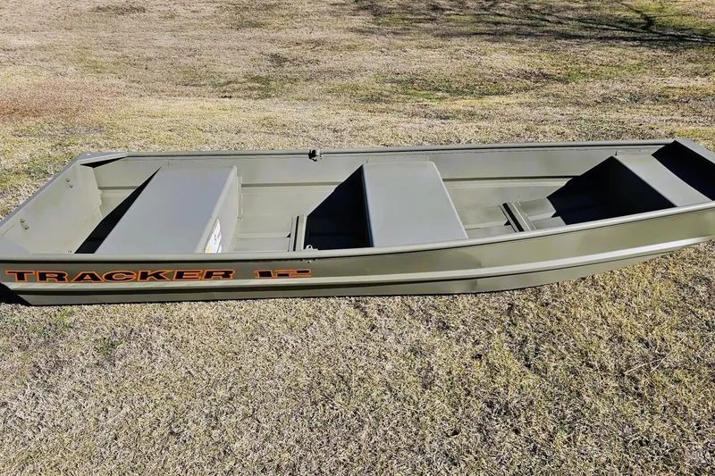 The Image of 2026 Tracker Grizzly 12 Jon boat on grass, showcasing its sturdy design and spacious interior. - 0