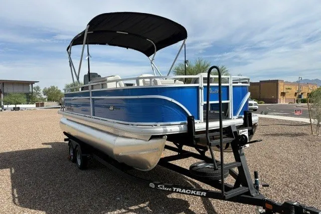 Slide: The Image of 2026 Sun Tracker Fishin' Barge 20 DLX pontoon boat on trailer, blue exterior. - 1