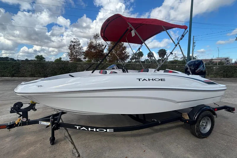 The Image of 2026 Tahoe T16 boat with red canopy on trailer under blue sky. - 0