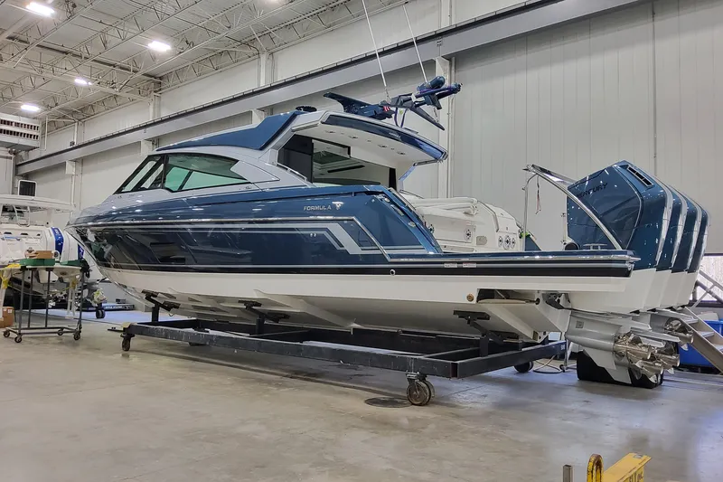 The Image of 2026 Formula 500 Super Sport Crossover boat in a showroom, showcasing sleek design and powerful engines. - 1