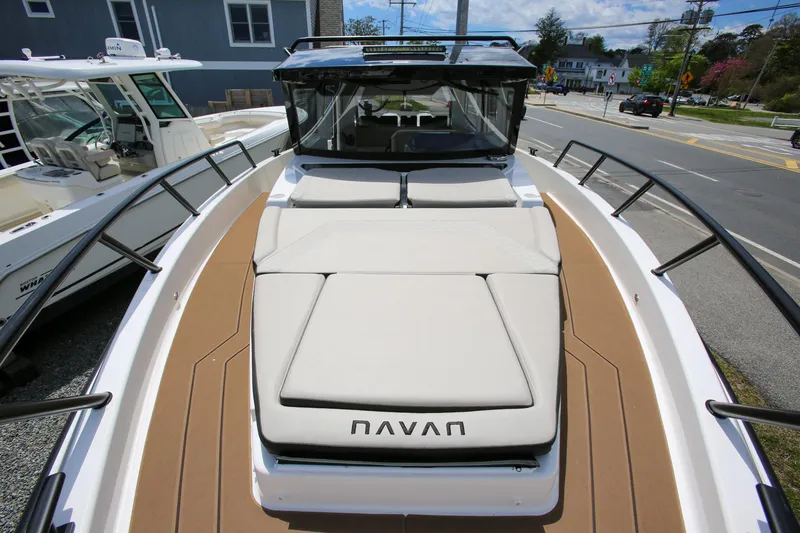 Slide: The Image of 2026 Navan C30 boat with spacious deck and cushioned seating, docked near a road. - 26