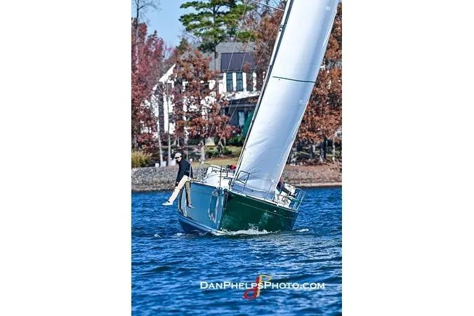 Slide: The Image of Sailboat Beneteau First 36.7 (2005) navigating a lake with autumn foliage backdrop. - 12