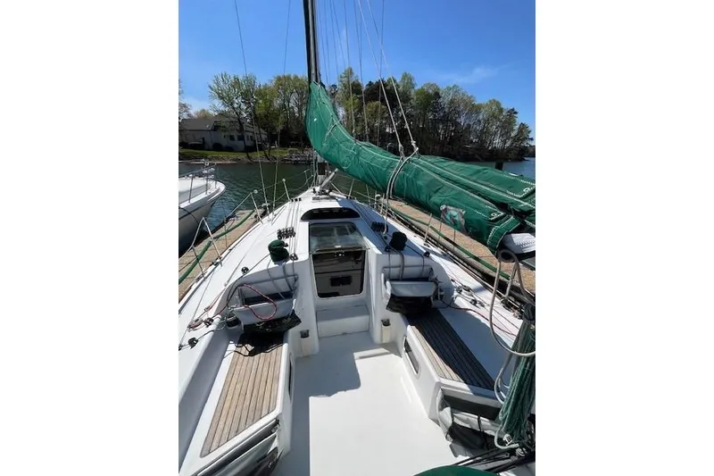 Slide: The Image of 2005 Beneteau First 36.7 sailboat with green sail cover, docked in a marina. - 13