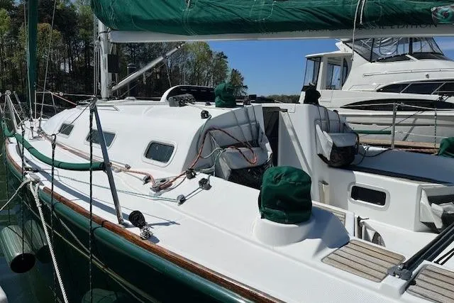 Slide: The Image of 2005 Beneteau First 36.7 sailboat docked, featuring green sail covers and sleek white deck. - 16