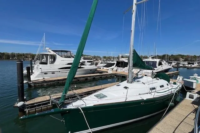 Slide: The Image of Sailboat docked at marina, 2005 Beneteau First 36.7, green hull, clear blue sky. - 2