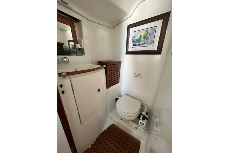 Slide: The Image of Compact bathroom in a 2005 Beneteau First 36.7 yacht, featuring a toilet and framed artwork. - 27