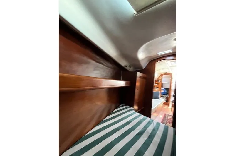 Slide: The Image of Interior cabin of 2005 Beneteau First 36.7 sailboat with striped bedding and wooden finish. - 37