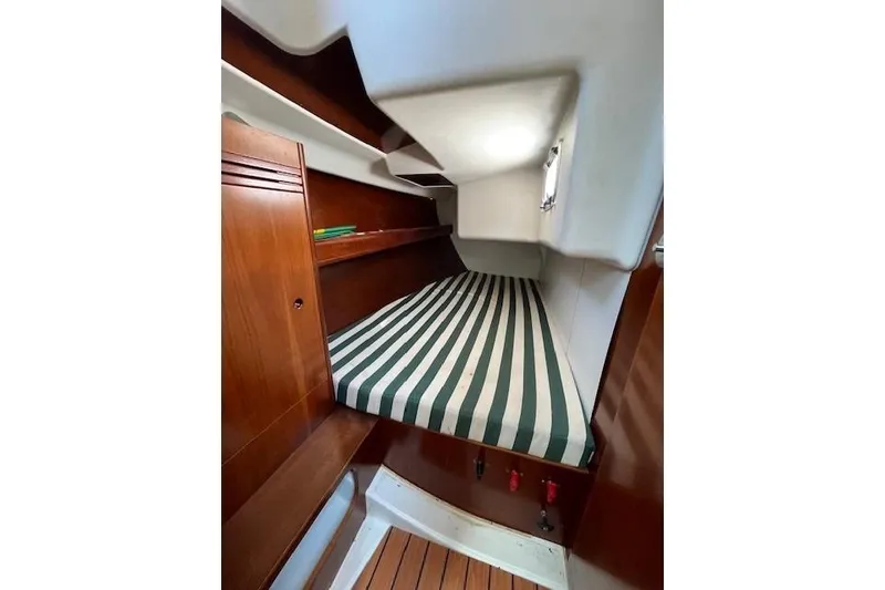 Slide: The Image of Cozy cabin interior of 2005 Beneteau First 36.7 sailboat with striped bedding. - 38