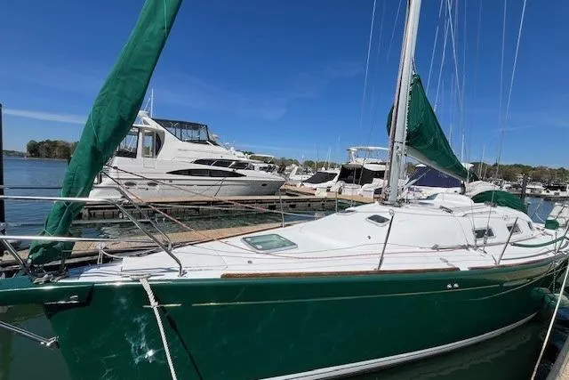 Slide: The Image of 2005 Beneteau First 36.7 sailboat docked, green hull and sails, marina background. - 7