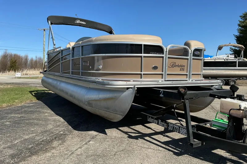 The Image of 2015 Berkshire 230E STS pontoon boat on trailer, parked outdoors. - 1