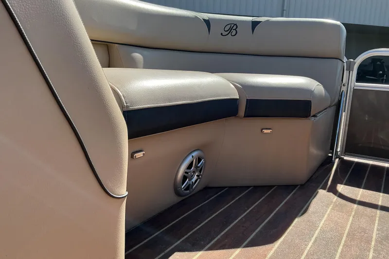 Slide: The Image of 2015 Berkshire 230E STS boat interior with beige seating and speaker. - 12