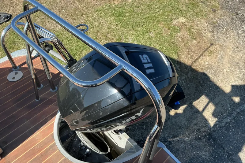 Slide: The Image of 2015 Berkshire 230E STS boat with Mercury 115 outboard motor, docked on wooden deck. - 14
