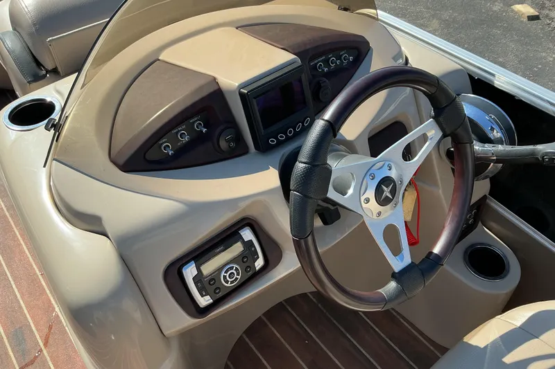 Slide: The Image of Steering console of a 2015 Berkshire 230E STS boat with modern controls and wood accents. - 15