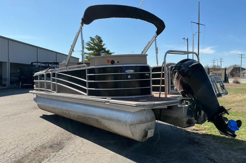 Slide: The Image of 2015 Berkshire 230E STS pontoon boat with outboard motor, parked outdoors. - 5
