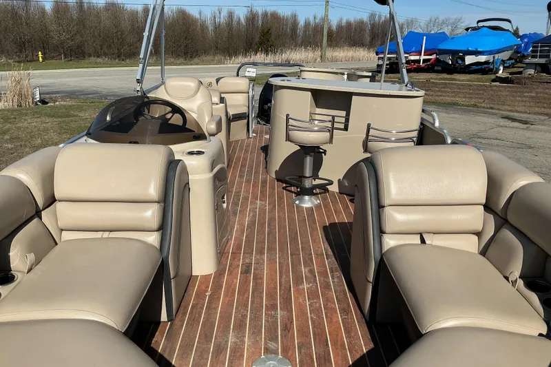Slide: The Image of 2015 Berkshire 230E STS pontoon boat with beige seating and wooden deck. - 6