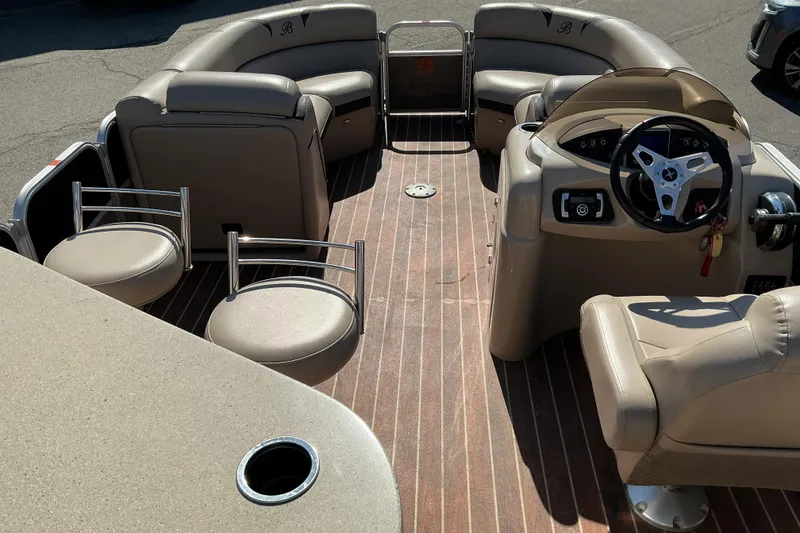 Slide: The Image of Interior of a 2015 Berkshire 230E STS pontoon boat with beige seating and steering console. - 7