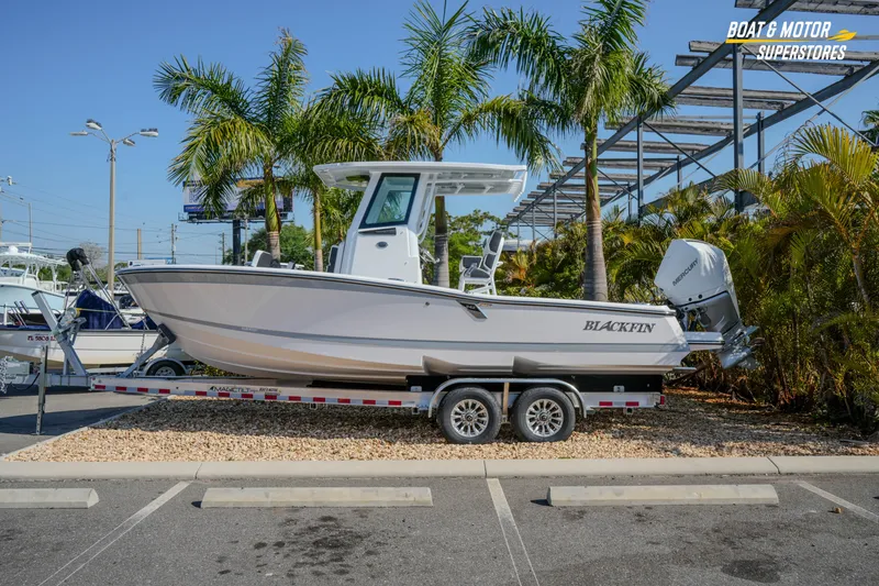 The Image of 2026 Blackfin 242 HB boat on trailer, parked near palm trees at dealership. - 1