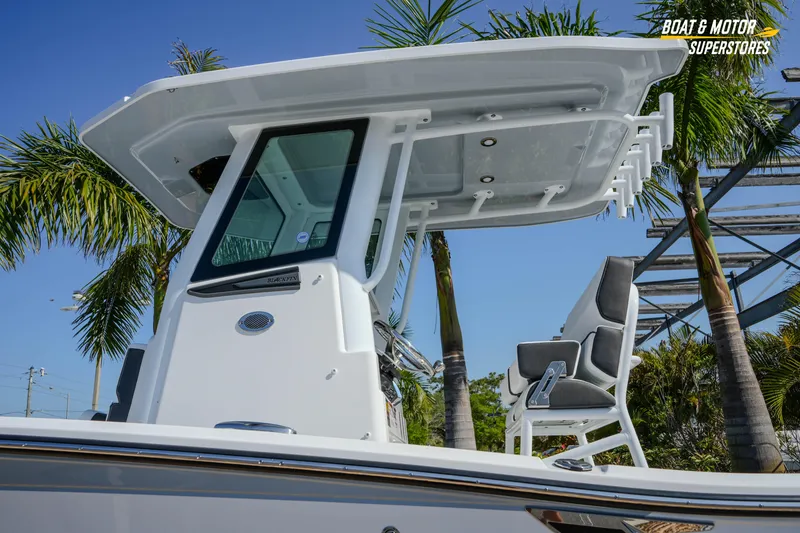 Slide: The Image of 2026 Blackfin 242 HB boat with T-top and seating, surrounded by palm trees. - 4