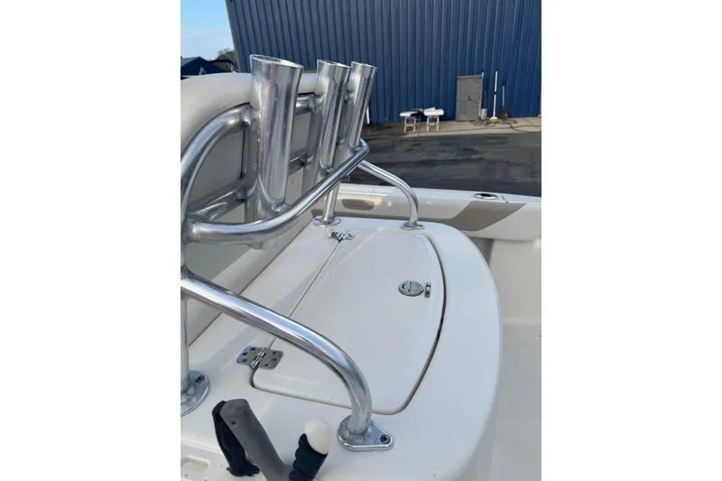 Slide: The Image of Rod holders on a 2013 Pioneer 197 Sportfish boat, docked near a blue building. - 12