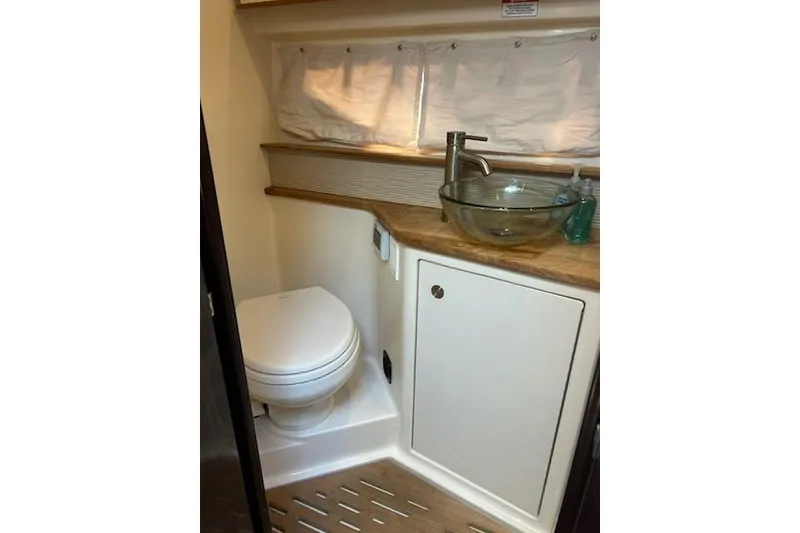 Slide: The Image of 2019 Sea Ray Sundancer 350 Coupe bathroom with modern sink and toilet. - 14