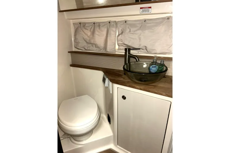 Slide: The Image of 2019 Sea Ray Sundancer 350 Coupe bathroom with modern sink and toilet. - 15