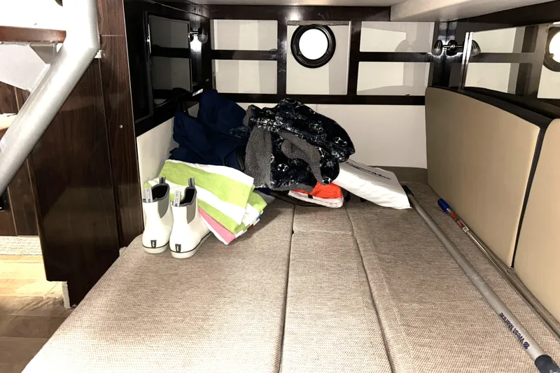 Slide: The Image of Interior cabin of 2019 Sea Ray Sundancer 350 Coupe with storage items and porthole windows. - 17