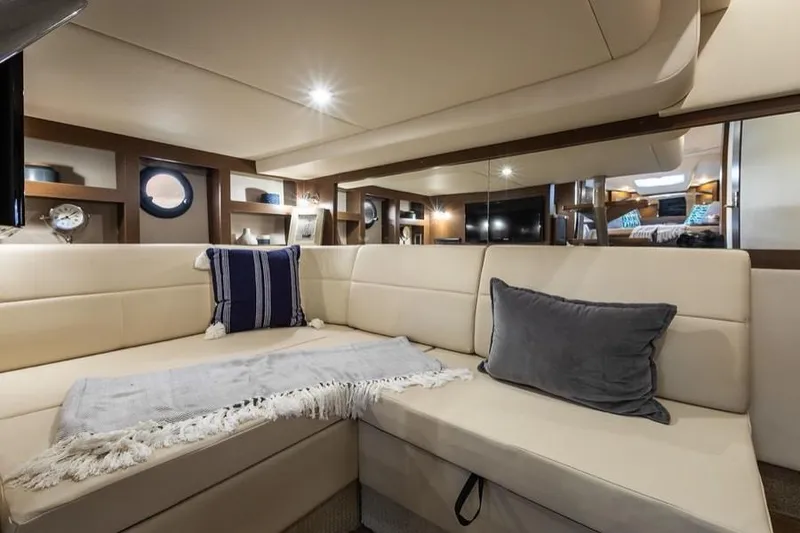 Slide: The Image of Manufacturer Provided Image: Luxurious interior of 2019 Sea Ray Sundancer 350 Coupe with beige seating and decorative pillows. - 24