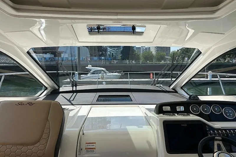 Slide: The Image of Interior view of 2019 Sea Ray Sundancer 350 Coupe yacht cockpit with cityscape background. - 4