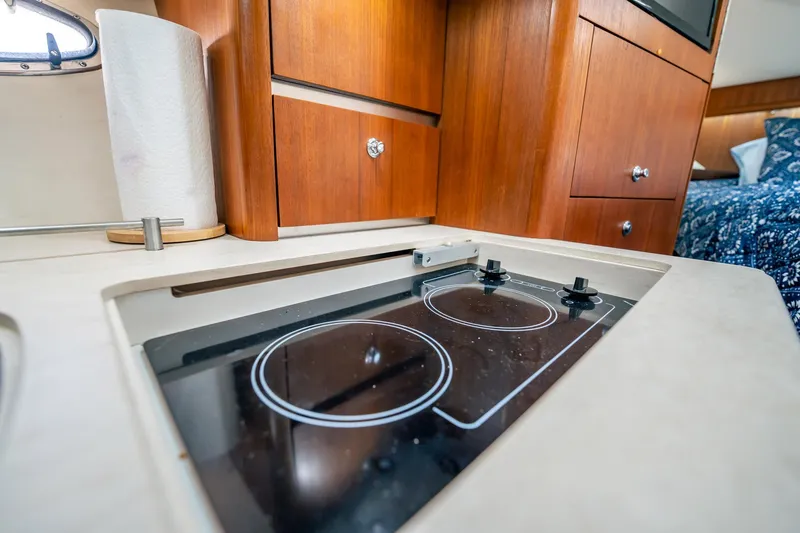 Slide: The Image of 2005 Tiara Yachts 3200 Open galley with stove and wooden cabinetry. - 15