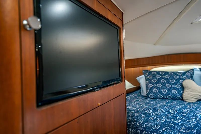 Slide: The Image of Luxurious cabin interior of 2005 Tiara Yachts 3200 Open with TV and patterned bedding. - 16