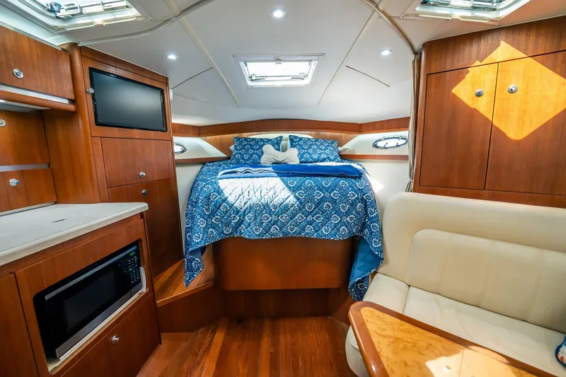 Slide: The Image of Luxurious 2005 Tiara Yachts 3200 Open cabin interior with cozy bed and modern amenities. - 17