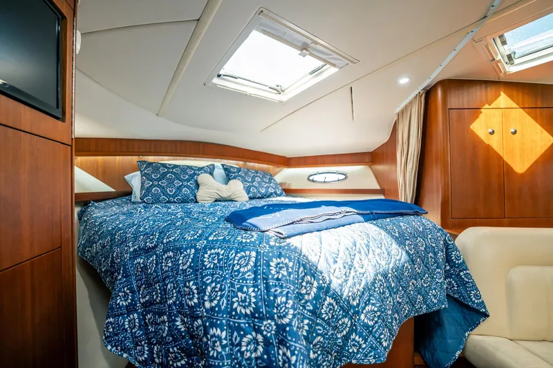 Slide: The Image of Luxurious cabin interior of 2005 Tiara Yachts 3200 Open with cozy bedding and wood finishes. - 19