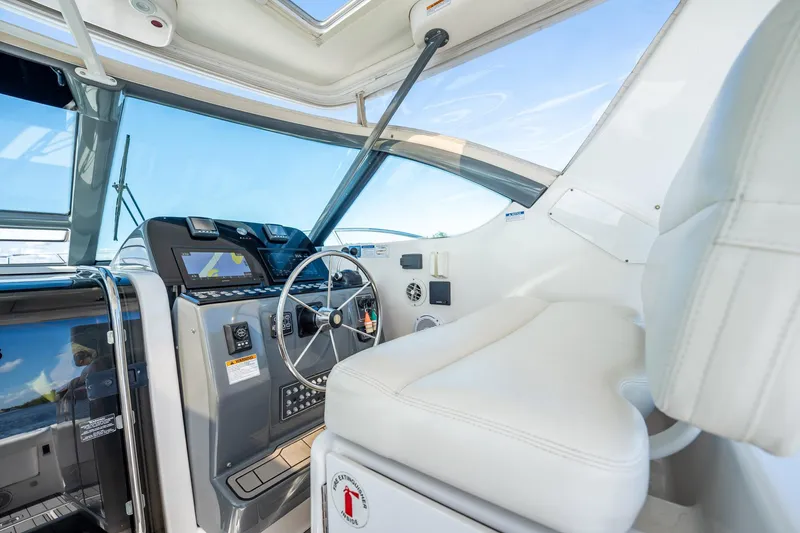 Slide: The Image of 2005 Tiara Yachts 3200 Open helm with modern controls and white seating. - 38