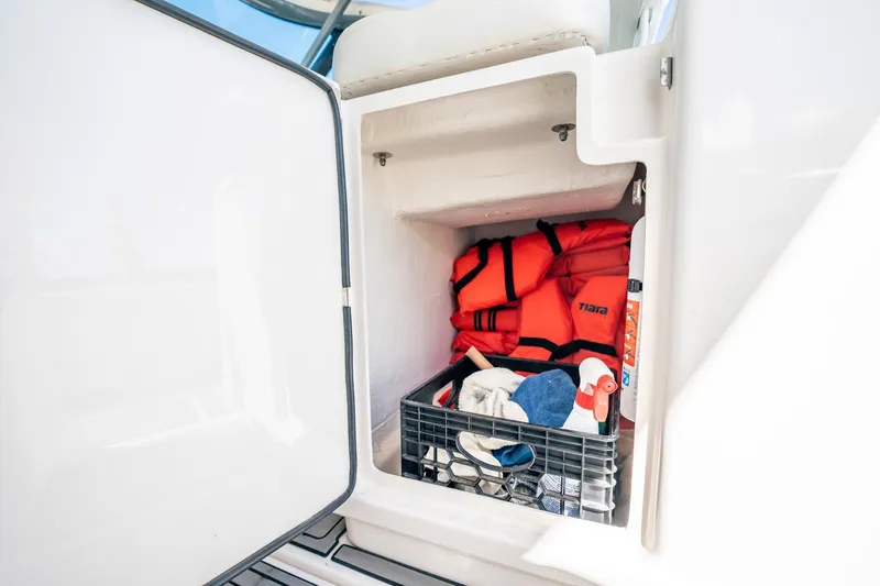 Slide: The Image of Storage compartment on 2005 Tiara Yachts 3200 Open with life jackets and cleaning supplies. - 42