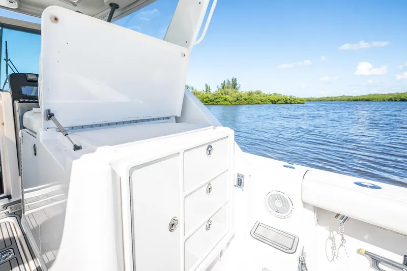 Slide: The Image of 2005 Tiara Yachts 3200 Open interior with storage, overlooking serene water and lush greenery. - 47