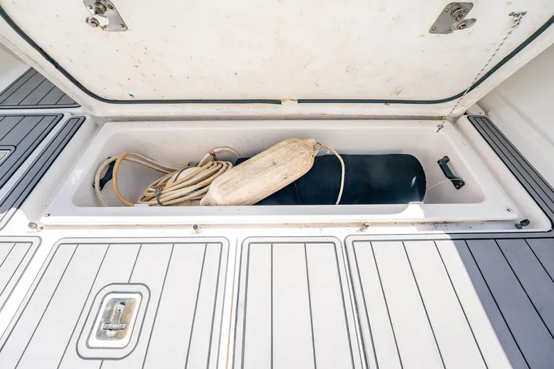Slide: The Image of Open storage compartment on 2005 Tiara Yachts 3200 Open, containing rope and fender. - 57