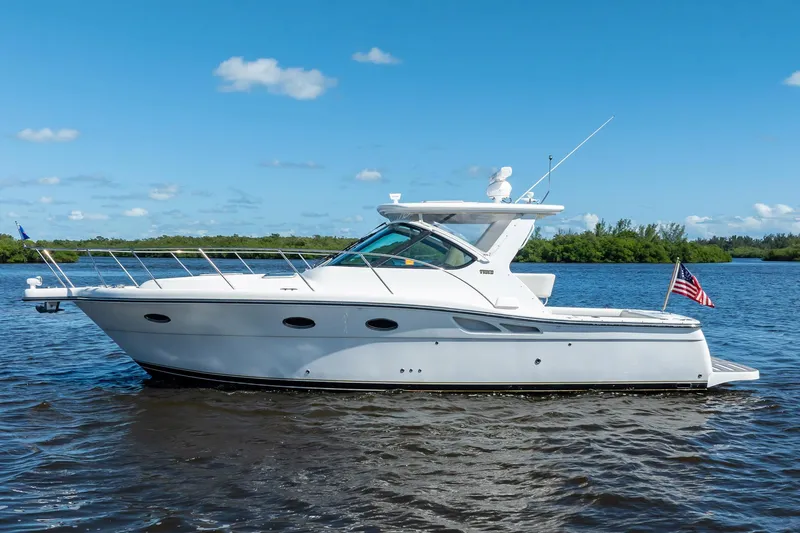Slide: The Image of 2005 Tiara Yachts 3200 Open cruising on a sunny day, displaying sleek design and American flag. - 6