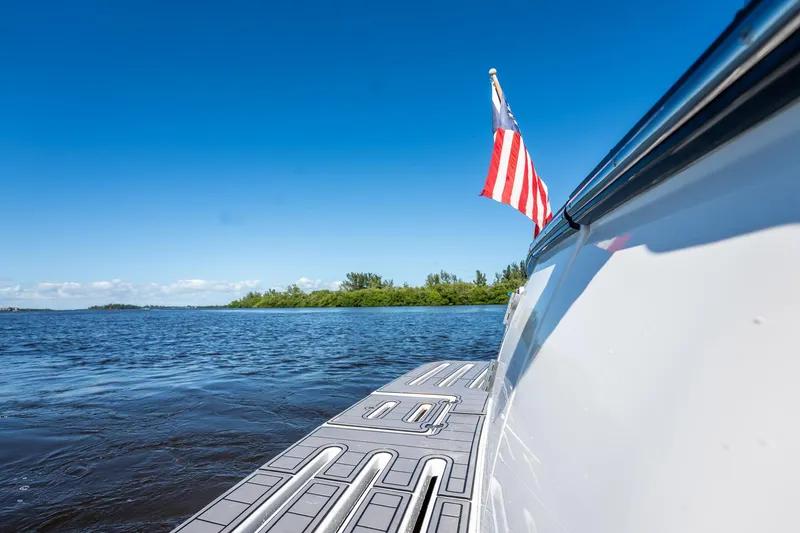 Slide: The Image of 2005 Tiara Yachts 3200 Open on water, American flag, clear blue sky. - 61