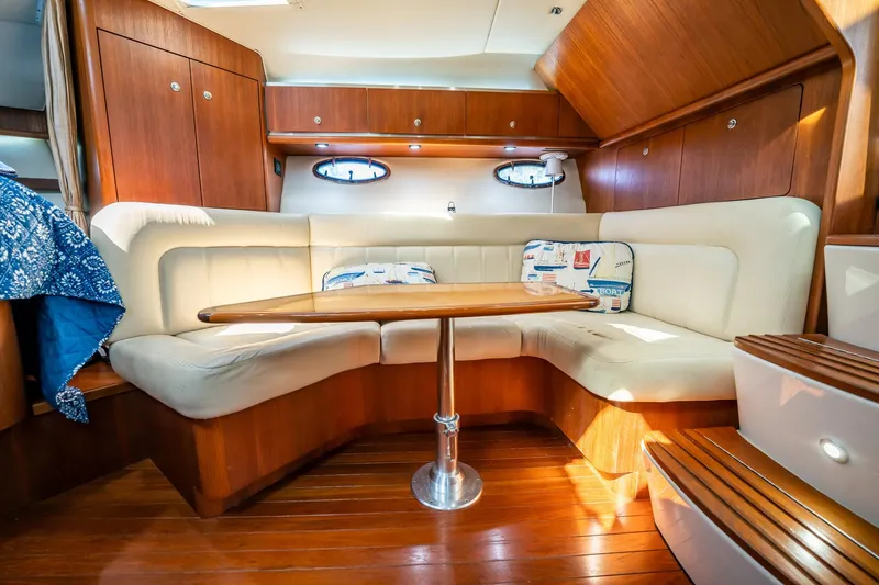 Slide: The Image of 2005 Tiara Yachts 3200 Open interior with cozy seating and wooden accents. - 9