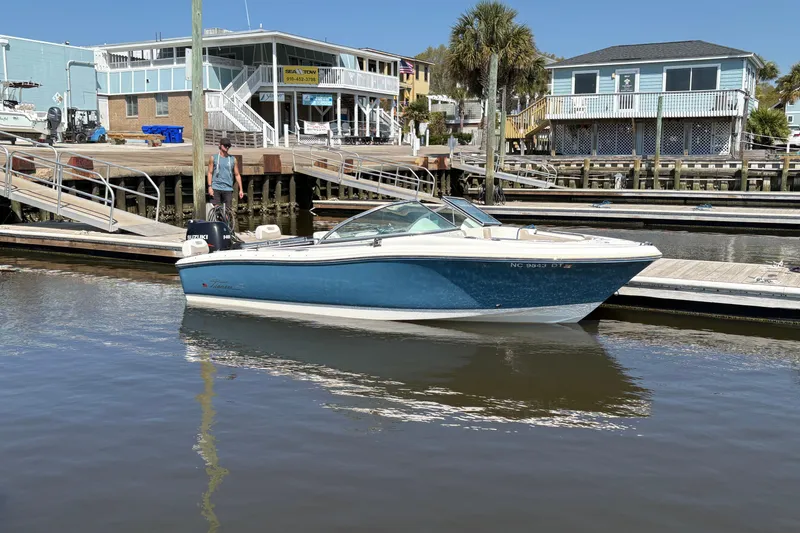 The Image of 2012 Pioneer 197 Venture boat docked at marina with waterfront buildings. - 0