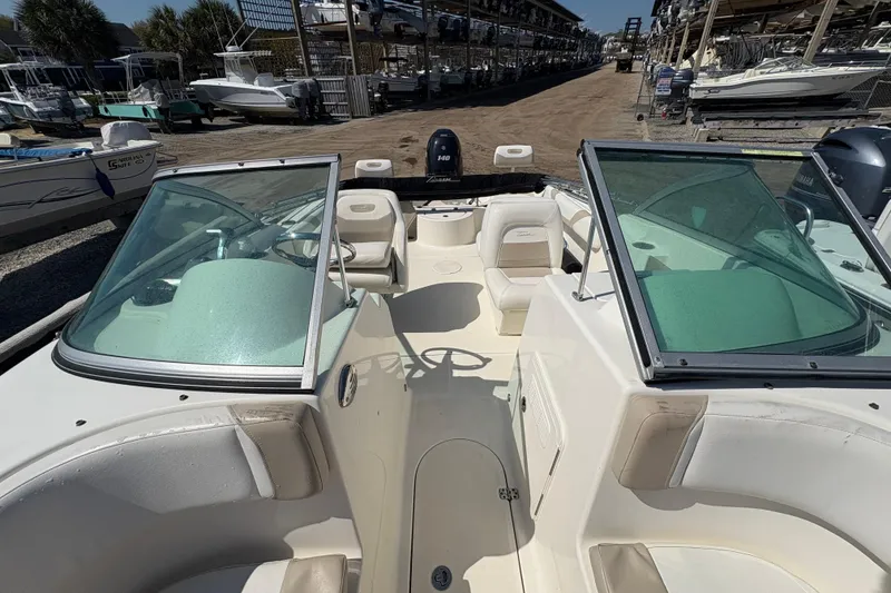 Slide: The Image of 2012 Pioneer 197 Venture boat interior with seating and windshield, docked at a marina. - 13