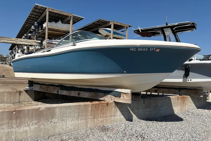 Slide: The Image of 2012 Pioneer 197 Venture boat on dry dock, blue hull, sunny day. - 5