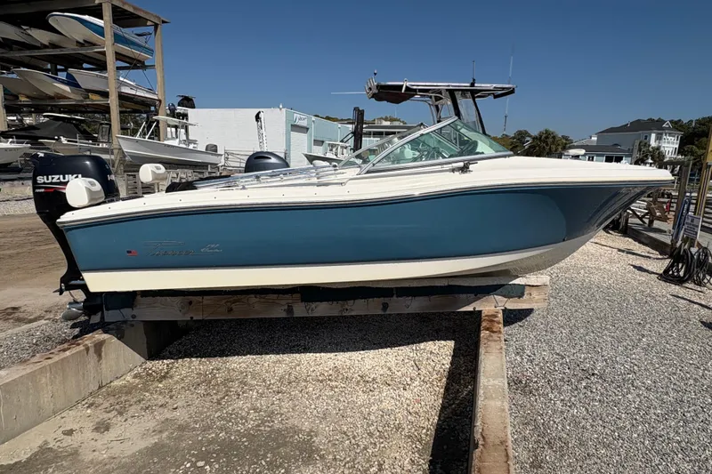 Slide: The Image of 2012 Pioneer 197 Venture boat on dry dock, blue and white hull, Suzuki outboard motor. - 7