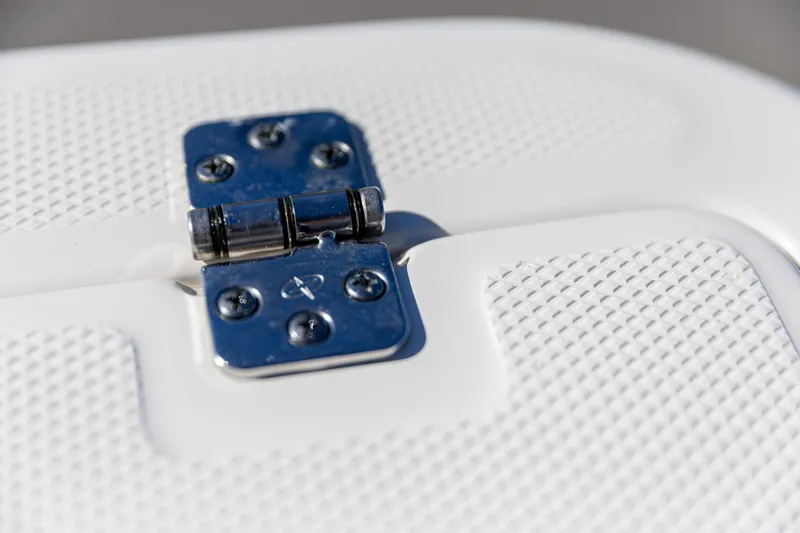 Slide: The Image of Close-up of a 2022 Edgewater 245CC boat hinge on textured white surface. - 13